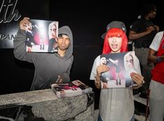 two people standing next to each other holding up pictures