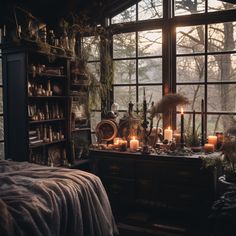 a bedroom with candles lit in front of the window