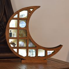 a wooden sculpture with many different items in the shape of a half moon on top of a table