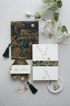 the wedding stationery is laid out on top of each other, with flowers and greenery