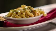 a white bowl filled with macaroni and cheese on top of a red napkin