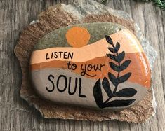 a rock that has been painted with the words listen to your soul