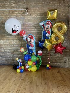 balloons and heliums in the shape of mario's characters are displayed on a wooden floor