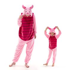 two people in pig costumes standing next to each other with their hands on their heads