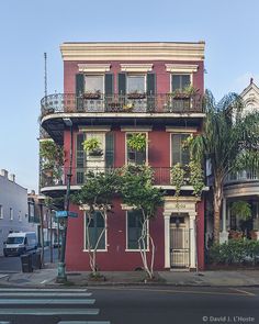 a red building with balconies and plants on it