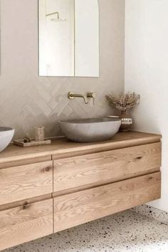 two sinks are on top of a wooden cabinet in the bathroom, while a mirror hangs above them