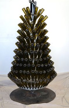 a wine bottle christmas tree made out of empty bottles is displayed on a white surface