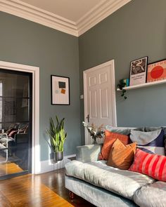 a living room filled with furniture and pictures on the wall