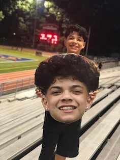 two young boys are sitting in the bleachers