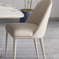 a white chair sitting in front of a table with a potted plant on it