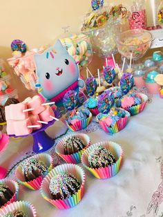 a table topped with lots of cupcakes and candy