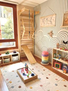 a child's playroom with toys, bookshelf and stairs in the corner