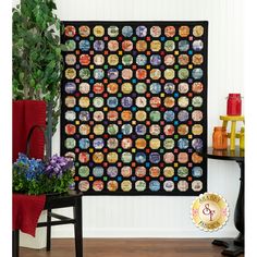 a black quilt with many different images on it and a potted plant next to it