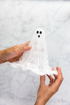 two hands are holding a plastic ghost