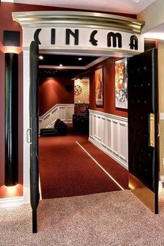 an open door leading to a movie room with red carpeting and white trimming