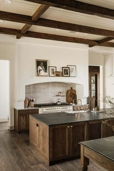 a large kitchen with wooden cabinets and black counter tops, along with pictures on the wall