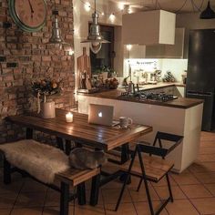 a kitchen with a table and chairs next to a clock on the wall above it