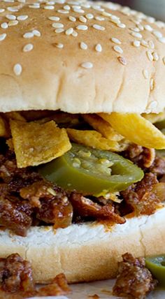 a close up of a sandwich on a plate with pickles and onions next to it