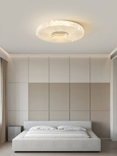 a large white bed sitting in a bedroom next to a wall mounted ceiling light fixture