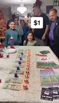 a group of people standing around a table with cards on it and candles in front of them