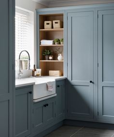 a kitchen with blue cabinets and white sink