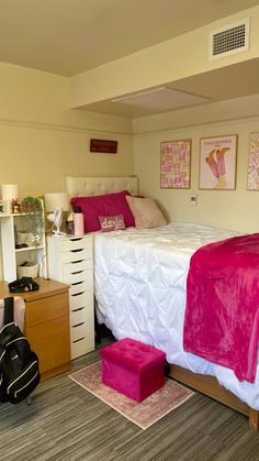 a bed room with a neatly made bed next to a chest of drawers and a guitar