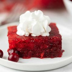 a slice of cherry cheesecake on a plate with whipped cream