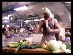 a man standing in front of a table with vegetables on it and an apron over his head