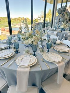 the table is set with blue and white plates, silverware, and napkins