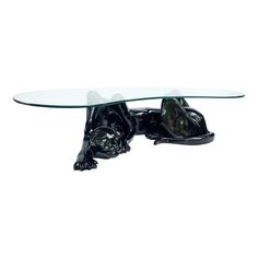 a glass table topped with a black dog figurine sitting on top of it