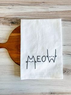 a wooden spoon sitting on top of a white napkin with the word meow printed on it