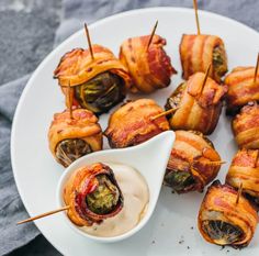 bacon wrapped vegetables on skewers with dipping sauce