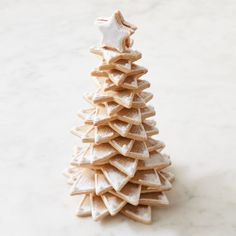 a christmas tree made out of cookies on a white countertop with a star decoration