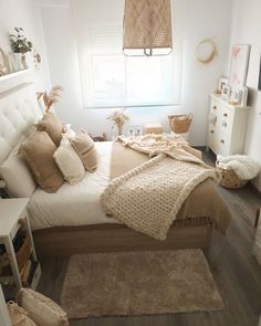 a bedroom with a bed, rugs and pillows on the floor in front of a window