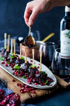 a person dipping some food on top of a white plate with cranberry sauce