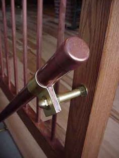 an open door with a handle on it and a wooden hand rail in the background