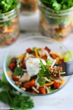 a glass bowl filled with salad and topped with sour cream