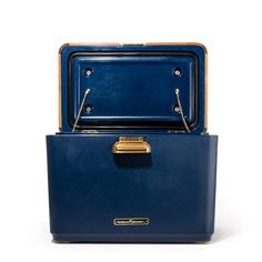 two pieces of blue luggage stacked on top of each other, one with gold handles