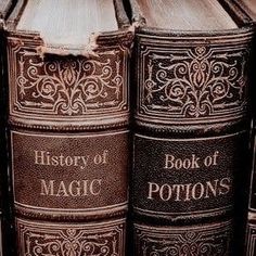 an old book sitting on top of each other in front of a wooden table with the words history of magic written on it