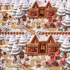 a christmas village with lots of snow covered trees and small wooden houses in the middle