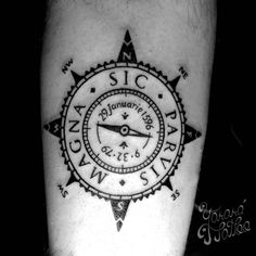 a black and white photo of a compass tattoo on the left arm with words written below it