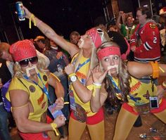 two women dressed in yellow and red cheer for the team at a sporting event with their hands up