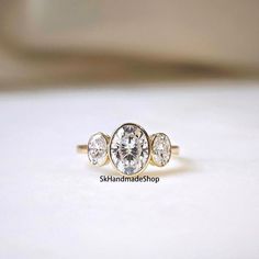 3 TCW Oval Cut Colorless Moissanite Engagement Ring, Bezel Setting Proposal Ring, Three Stone Ring, 18k Yellow Gold Ring, Gift For Special  Detail about stones Moissanite & Simulated Stone: ----------------------------- Stone Shape: Oval Cut Stone Size: 9x7 mm, 6x4 mm  Weight: 3 TCW  Color: Colorless Cut: Excellent Clarity: VVS Personalization Metal Selection: 925 Sterling Silver/10k/14k/18k/Platinum Metal Color: Rose Gold/White Gold/Yellow Gold Engrave Available as per your choice(special surprised Words, Name, Date & more) If you have any queries related to any Jewelry feel free to contact me. We will try our best to figure out the  problem and gives a solution Thank you for taking your precious time to visit my shop. I hope you get what you want in my shop. I feel very  pleased to deliv Engagement Ring Bezel, Ring Three Stone, Ring Bezel, Three Stone Ring, Gold Engraving, 18k Yellow Gold Ring, Platinum Metal, Proposal Ring, Three Stone Rings