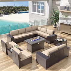 an outdoor living room with furniture and a fire pit on the deck overlooking the water