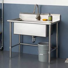 a white sink sitting under a faucet next to a trash can