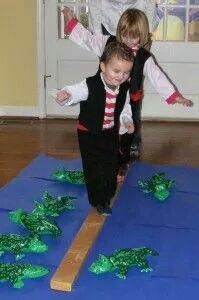 two children are jumping on the floor in front of some fake green plants and grass