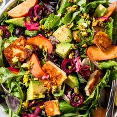 a salad with avocado, lettuce, carrots and other vegetables