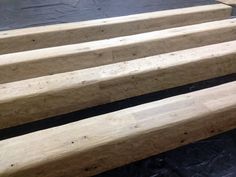 three wooden benches sitting on top of a black tarp