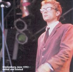 a man in a suit and tie standing next to a microphone with words on it