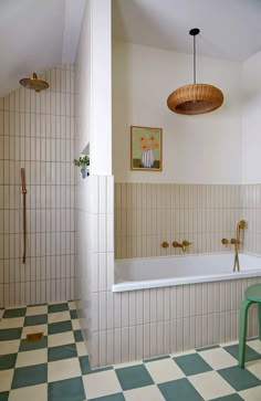 a bathroom with green and white checkered flooring next to a bathtub in the corner